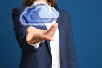 Woman holding virtual clouds icon on blue background, closeup of hand. Data storage concept