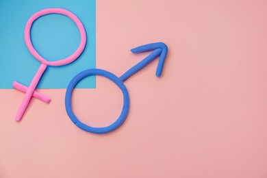 Photo of Male and female symbols of plasticine on color background, flat lay. Gender equality