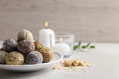 Different delicious vegan candy balls on light grey marble table. Space for text