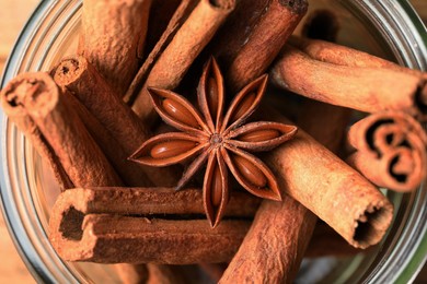 Bowl with aromatic cinnamon sticks and anise star on table, closeup