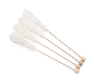 Photo of Wooden sticks with sugar crystals isolated on white, top view. Tasty rock candies