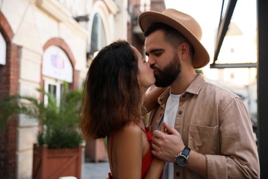 Photo of Happy young couple kissing on city street