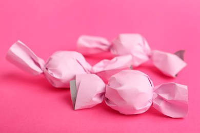 Candies in pink wrappers on bright background