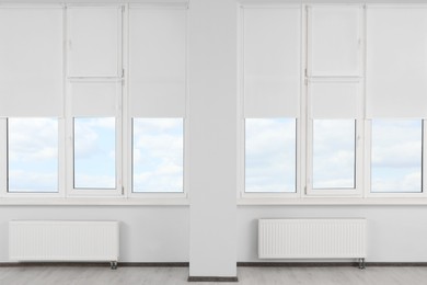 Plastic windows with white roller blinds indoors