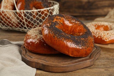 Delicious fresh bagels with poppy and sesame seeds on wooden table