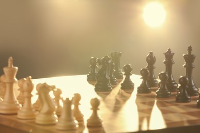 Photo of Chessboard with game pieces lit by lamp