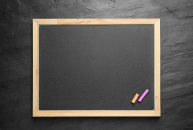Empty blackboard with chalk on slate background, top view. Space for text