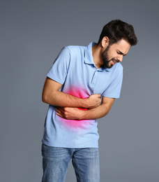 Image of Man suffering from stomach pain on grey background