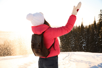 Young woman having fun outdoors on snowy winter day