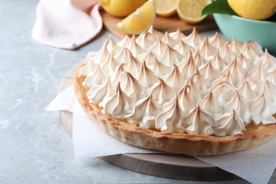 Delicious lemon meringue pie on light grey table, space for text