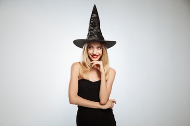 Beautiful woman in witch costume on white background. Halloween party