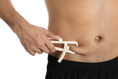 Man measuring body fat layer with caliper on white background, closeup. Nutritionist's tool
