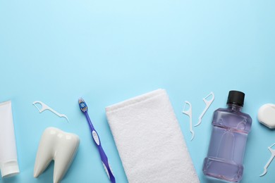 Flat lay composition with mouthwash and other oral hygiene products on light blue background. Space for text