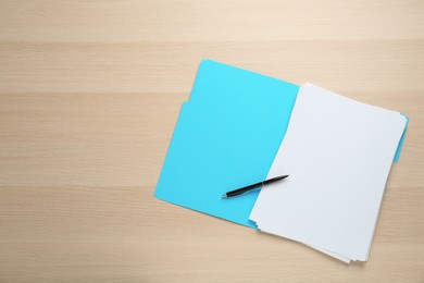 Turquoise file with blank sheets of paper and pen on wooden table, top view. Space for text