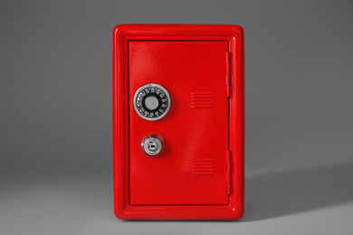Closed red steel safe on light grey background