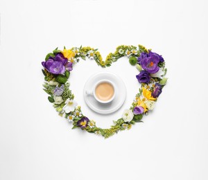 Beautiful heart made of different flowers and coffee on white background, top view