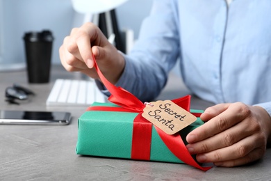Man opening present from secret Santa at workplace, closeup