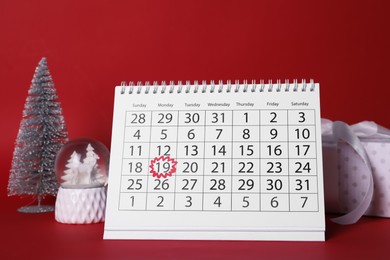 Saint Nicholas Day. Calendar with marked date December 19, gift box and festive decor on red background