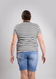 Fat woman on grey background. Weight loss