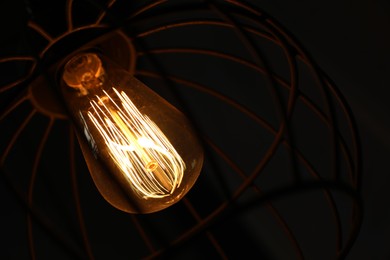 Photo of Stylish metallic pendant lamp with Edison light bulb indoors, closeup