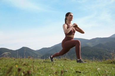 Young woman doing morning exercise in mountains, space for text