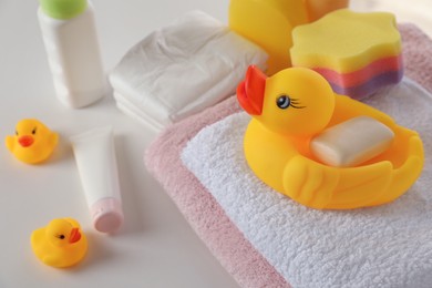 Photo of Towels, rubber ducks and baby care products on white table