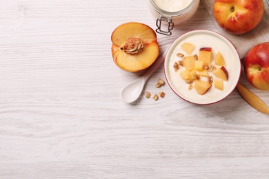 Delicious yogurt with fresh peach and granola on white wooden table, flat lay. Space for text