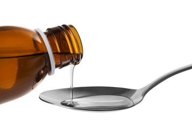 Pouring syrup into spoon from bottle isolated on white, closeup. Cough and cold medicine