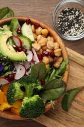 Photo of Delicious vegan bowl with broccoli, avocados and chickpeas on wooden table, flat lay