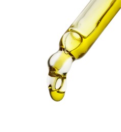Dripping yellow facial serum from pipette on white background, closeup