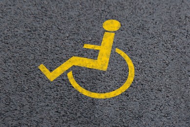 Image of Wheelchair symbol on asphalt road. Disabled parking permit