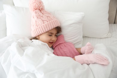 Photo of Ill girl with hot water bottle suffering from cold in bed at home