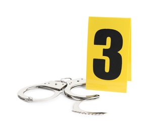Handcuffs and crime scene marker with number three isolated on white