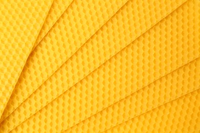 Photo of Natural beeswax sheets as background, top view