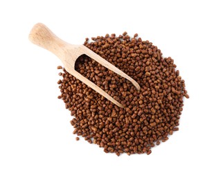 Photo of Wooden scoop with buckwheat tea granules on white background, top view