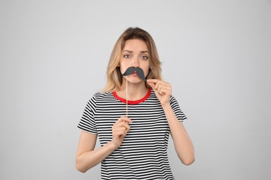 Photo of Funny woman with fake mustache on grey background