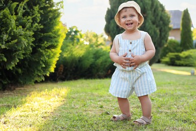 Cute little girl wearing stylish clothes outdoors on sunny day. Space for text
