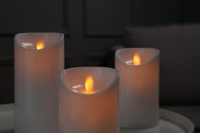 Decorative LED candles on white table indoors