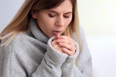 Sad woman suffering from cold on blurred background