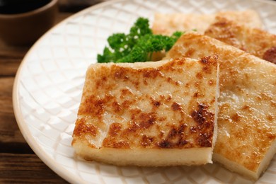 Delicious turnip cake with parsley on wooden table, closeup