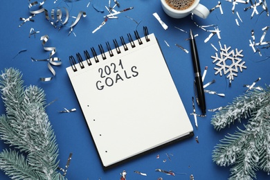 Inscription 2021 Goals in notebook, new year aims. Objects on blue background, flat lay