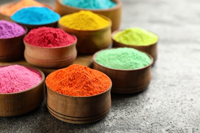 Colorful powder dyes on grey background, closeup. Holi festival