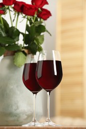 Photo of Glasses of delicious red wine indoors. Romantic date