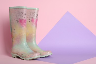 Pair of rubber boots on color background. Space for text