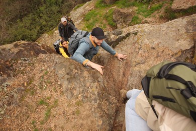 Group of hikers with backpacks climbing up mountains, above view
