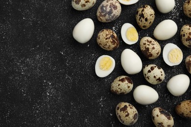 Photo of Peeled and unpeeled hard boiled quail eggs on black table, flat lay. Space for text