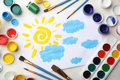 Flat lay composition with child's painting of sun and clouds on white wooden table