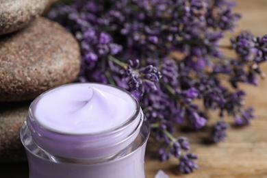 Stones, jar of cream and lavender flowers on table, closeup