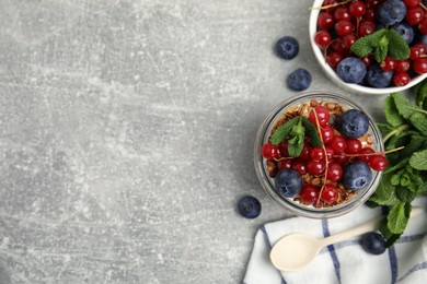 Delicious yogurt parfait with fresh berries and mint on light grey table, flat lay. Space for text