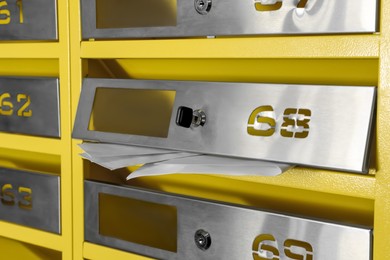 Metal mailboxes with keyholes, numbers and receipts, closeup